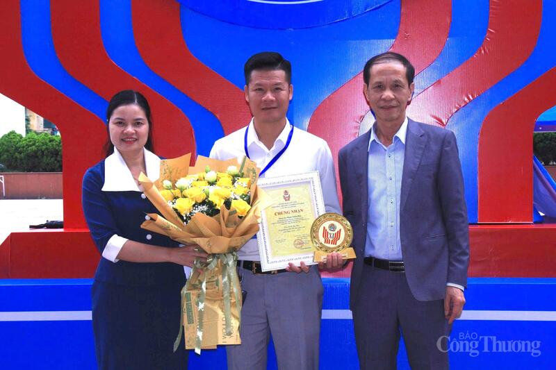 Ông Phạm Xuân Huy (đứng giữa) nhận hoa và quà lưu niệm từ lãnh đạo Công đoàn Công Thương Việt Nam. Ảnh: P.C