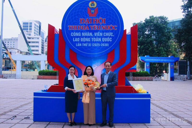 Bà Phan Hồng Huê (đứng giữa), đại diện Công đoàn cơ sở Tập đoàn Intimex nhận hoa và biểu trưng của Tổng Liên đoàn Lao động Việt Nam. Ảnh: P.C.