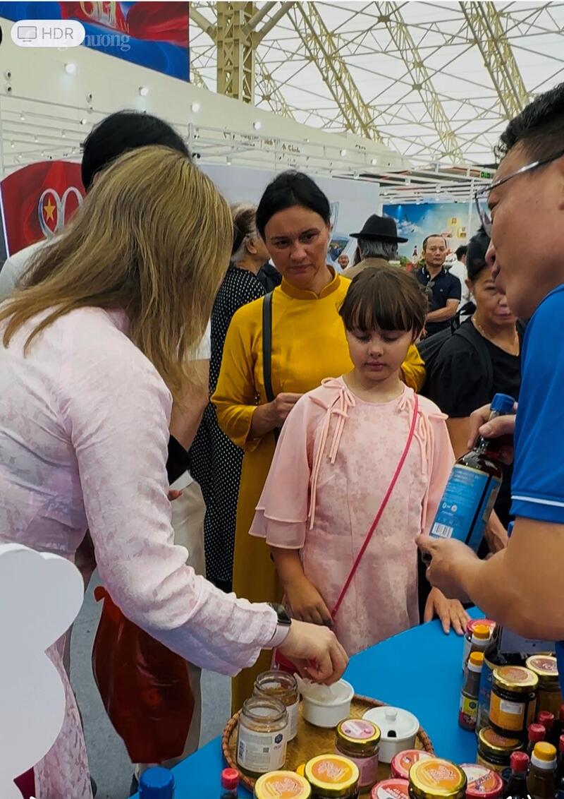 Vị khách nước ngoài đang trải nghiệm sản phẩm nước mắm truyền thống tại gian hàng của Công ty Lê Gia. Ảnh: NH