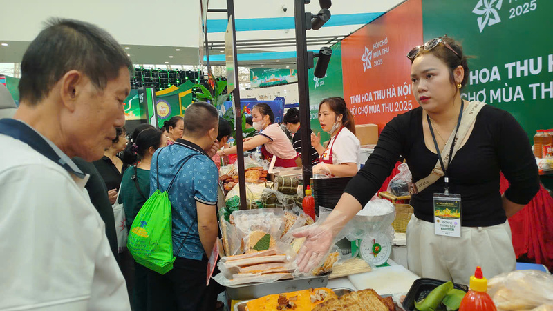 Chị Nguyễn Thị Thúy giới thiệu và mời khách hàng ăn thử sản phẩm.