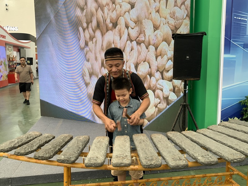 Nghệ nhân Nguyễn Duy Thảo hướng dẫn em nhỏ đánh đàn đá. (Ảnh: Mỹ Huyền)