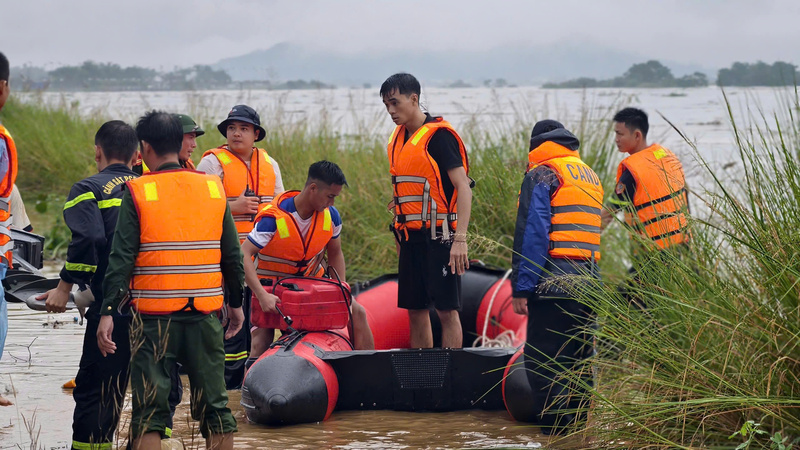 Lực lượng chứ năng sau tiến hành giải cứu người đàn ông bị mắc lại giữa dòng lũ. Ảnh: Nguyễn Dương