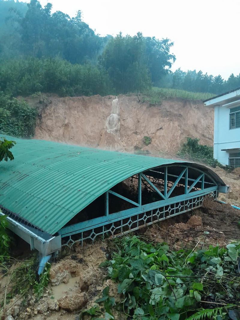 Đất từ trên ngọn đồi đổ ùn ùn xuống gần như lấp đến mái nhà để xe. Ảnh: Xã Tây Trà
