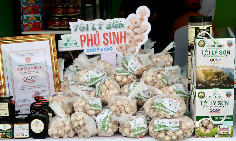 Gian hàng trưng bày của tỉnh Quảng Ngãi cũng giới thiệu nhiều đặc sản đạt chứng nhận OCOP, mang chủ đề “Đậm vị biển - Ngát hương rừng”. Nổi bật trong đó có tỏi Lý Sơn, cà phê Măng Đen, rượu nếp cái hoa vàng, rượu nếp cẩm Măng Đen… (Ảnh: Minh Châu)