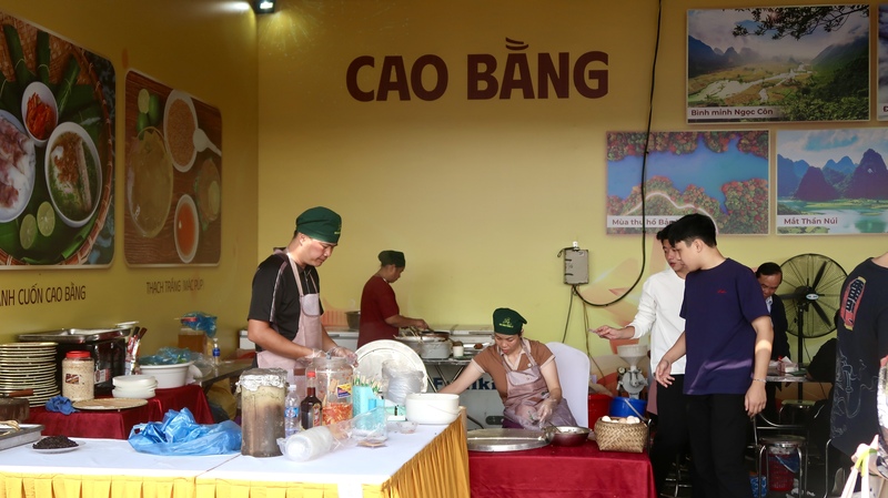 Khách hàng vừa xếp hàng vừa quan sát các nghệ nhân tráng chiếc bánh cuốn Cao Bằng. (Ảnh: Minh Châu)