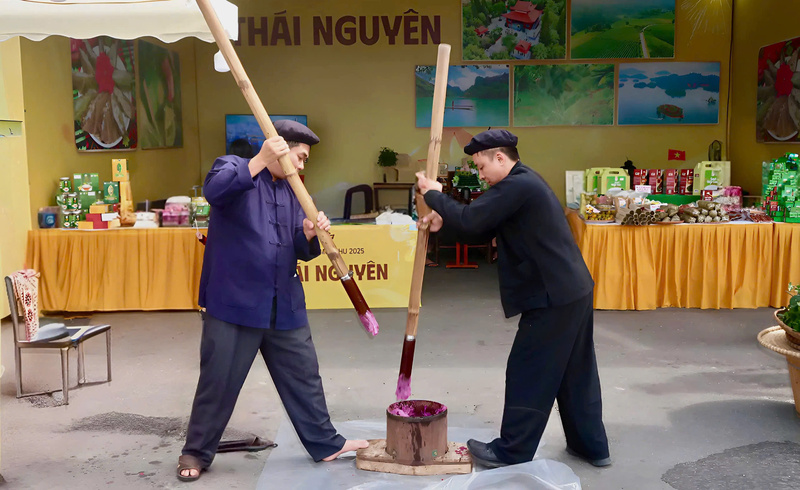 Thực khách bày tỏ sự thích thú khi được tận mắt chứng kiến quy trình giã bánh dày tím tại gian hàng ẩm thực của tỉnh Thái Nguyên. (Ảnh: Minh Châu)