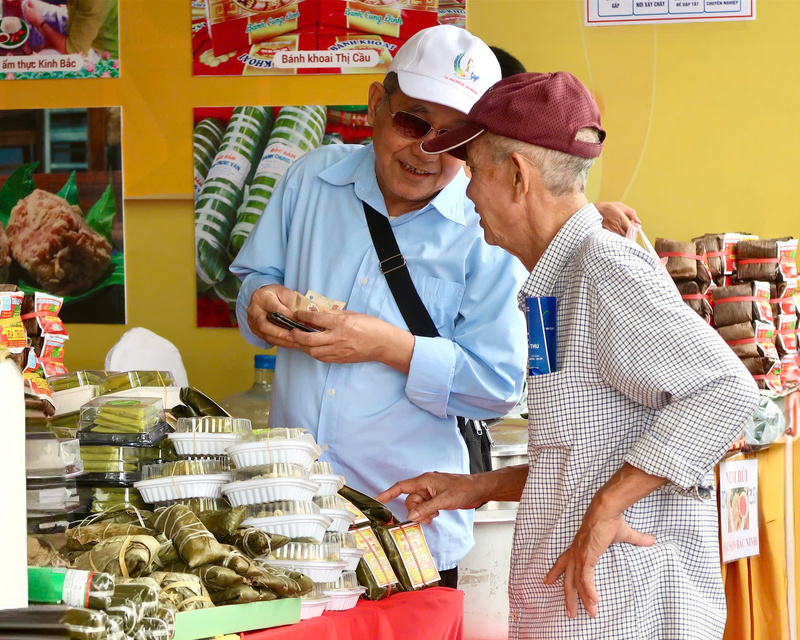 Du khách Lại Văn Sinh (áo xanh, bên trái) cho biết, không khílễ hội Thu Mỹ Vị rất đông vui, phấn khởi. Để trải nghiệm đầy đủ các hoạt động tại hội chợ, ông đã dậy từ 5 giờ sáng để kịp chuyến xe từ Bắc Ninh đến Hà Nội. “Tôi cảm thấy rất vui mừng khi thấy các món ăn xứ Kinh Bắc quê tôi được người dân đánh giá cao và lựa chọn mua làm quà tặng”, ông Sinh chia sẻ. (Ảnh: Minh Châu)