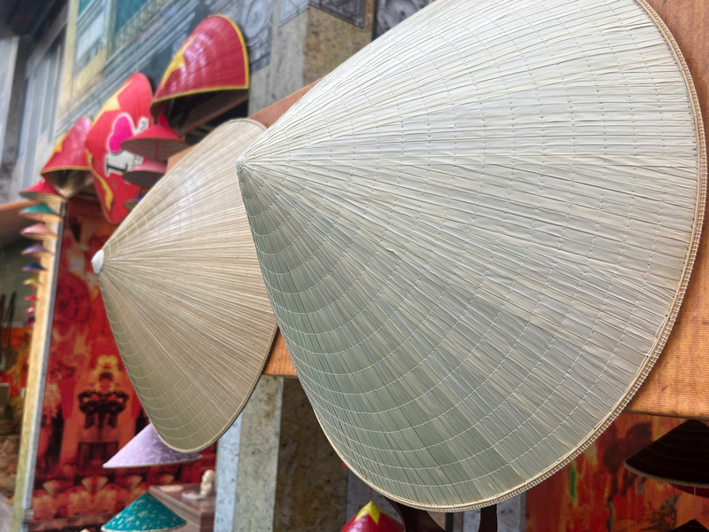 Cận cảnh nón lá truyền thống (chóp cao hơn) và nón lá ghép xương (chóp thấp và vành rộng hơn). Ảnh: Thanh Thảo.