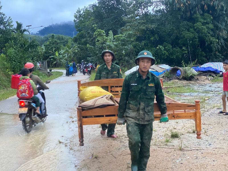 Bộ đội giúp người dân di chuyển đồ đạc, tài sản đến nơi an toàn. Ảnh: Bình An