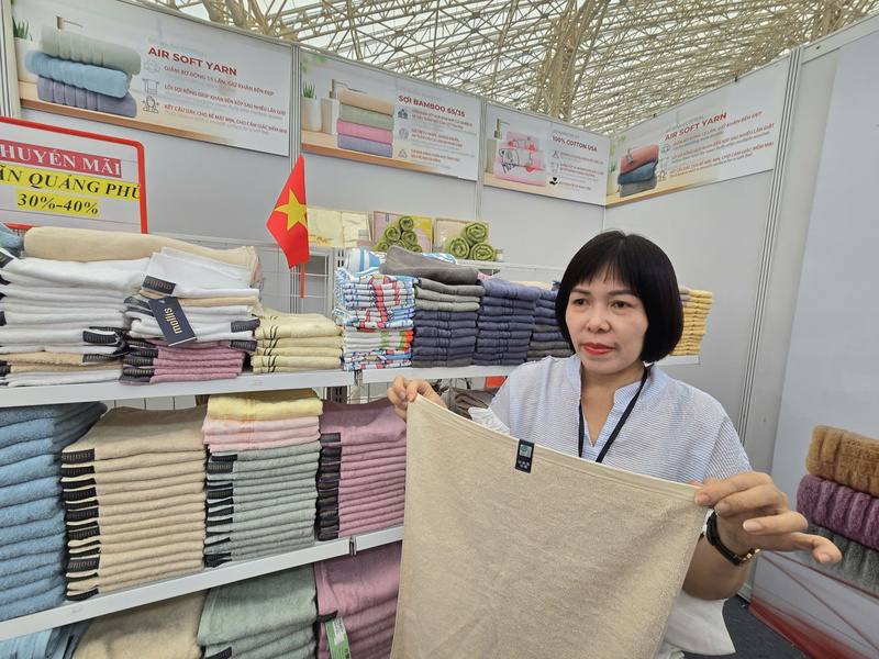 Bà Hồ Mai giới thiệu sản phẩm được sản xuất từ nguyên liệu tre của Dệt Phong Phú. Ảnh: Thu Hường