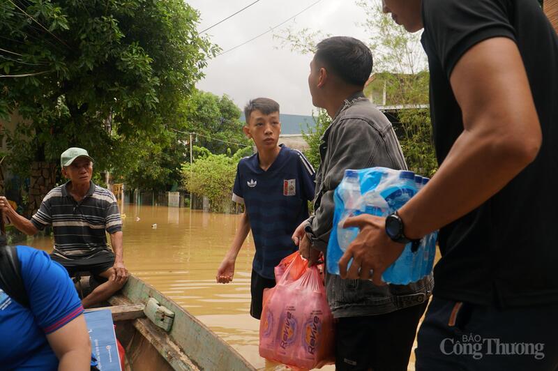 Với chiếc ghe nhỏ, ông Ba Thành và một số hộ dân có ghe thuyền trở thành những người vận chuyển nước, nhu yêu phẩm cho bà con trong thôn Đông Hòa bị cô lập bởi nước lũ