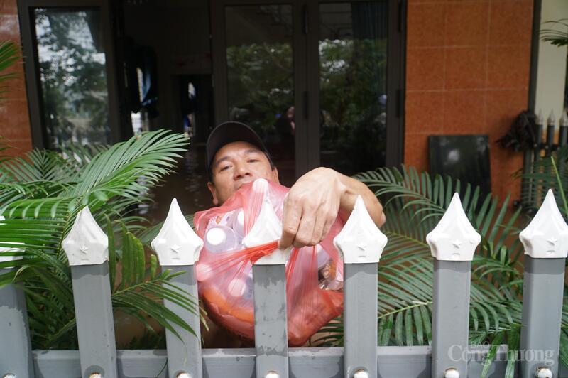 Người dân thôn Đông Hòa dầm mình trong nước lũ để ra nhận nước uống từ bên ngoài đưa vào