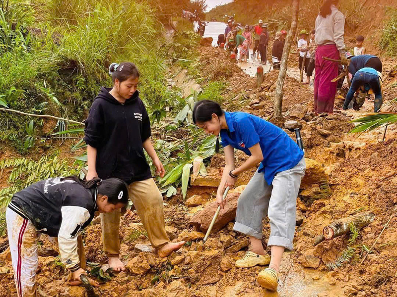 Cô giáo Trà Thị Thu cùng các học sinh góp sức cùng dọn bùn đất, rác thải. Ảnh: Tuệ Lâm