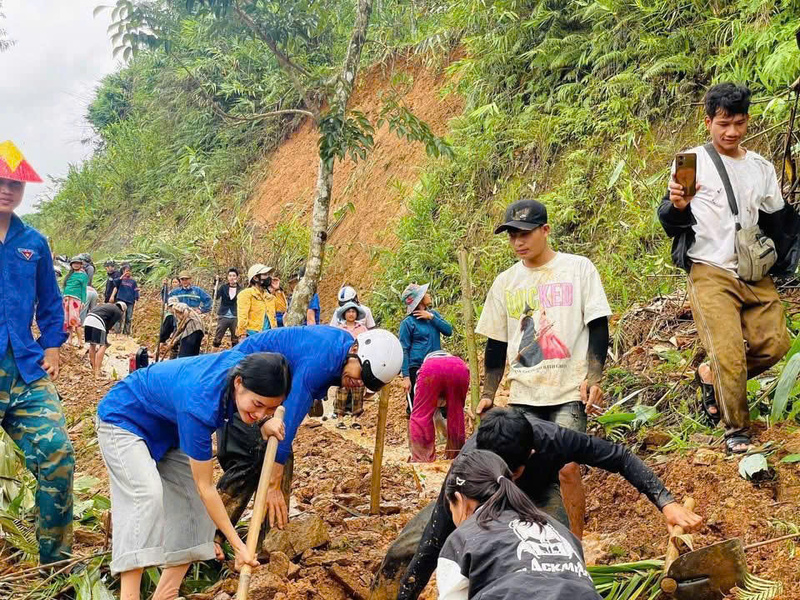 Ngay khi trời bắt đầu ngớt mưa, người dân cùng chính quyền địa phương xã Trà Tập tổ chức dọn dẹp những nơi sạt lởđể tạm thời đi lại. Ảnh: Tuệ Lâm