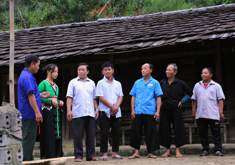 Ông Lầu Minh Pó (thứ 3 từ trái qua) đến nhà các gia đình ở bản Cơm (Pù Nhi) vận động bà con xóa bỏ hủ tục