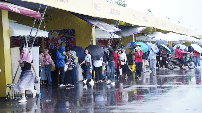 Nhiều người dân dầm mưa, xếp hàng chờ mua đặc sản tại các gian hàng Thu Mỹ Vị. Ảnh: Diệu Linh