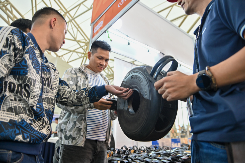 Khách tham quan hào hứng trải nghiệm và chọn mua các sản phẩm dép cao su tại gian hàng. Mỗi đôi dép đều được giới thiệu về chất liệu, quy trình làm thủ công và ý nghĩa lịch sử gắn liền với hình ảnh người lính Cụ Hồ.