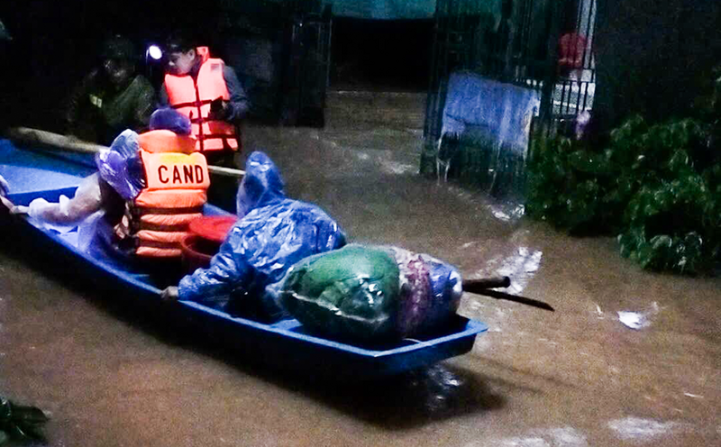 Lực lượng chức năng dùng thuyền giúp dân di tản đến nơi an toàn.