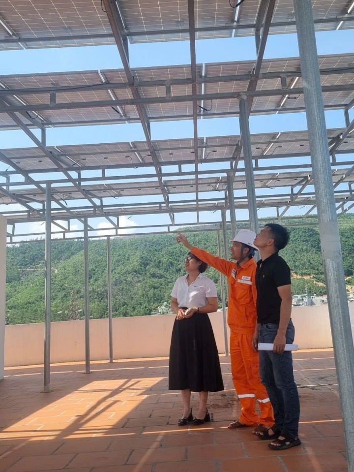 Công nhân Đội QLĐLKV Cẩm Phả giới thiệu và tuyên truyền cho các khách hàng hệ thông điện năng lượng mặt trời áp mái nhà. Ảnh:PCQN