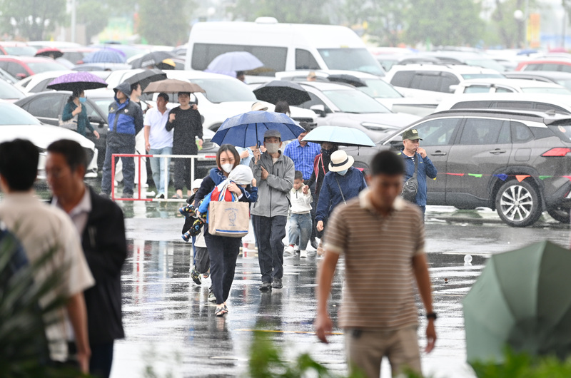 Mưa lớn liên tục trút xuống, làm chậm lại dòng xe cộ, nhưng không hề ngăn cản được dòng người đổ về hội chợ để mua sắm.