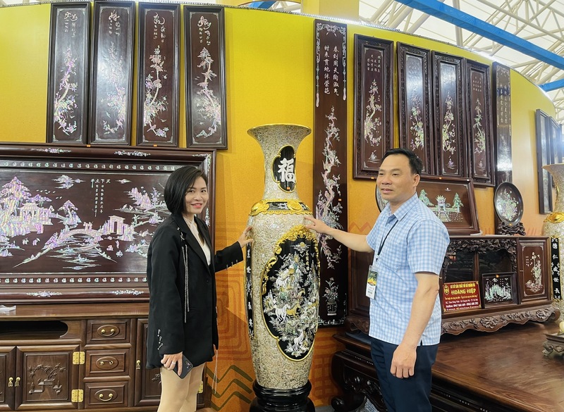 Anh Dương Văn Sinh đang giới thiệu với khách hàng về sản phẩm khảm ốc của cơ sở. Ảnh: Nguyễn Hương