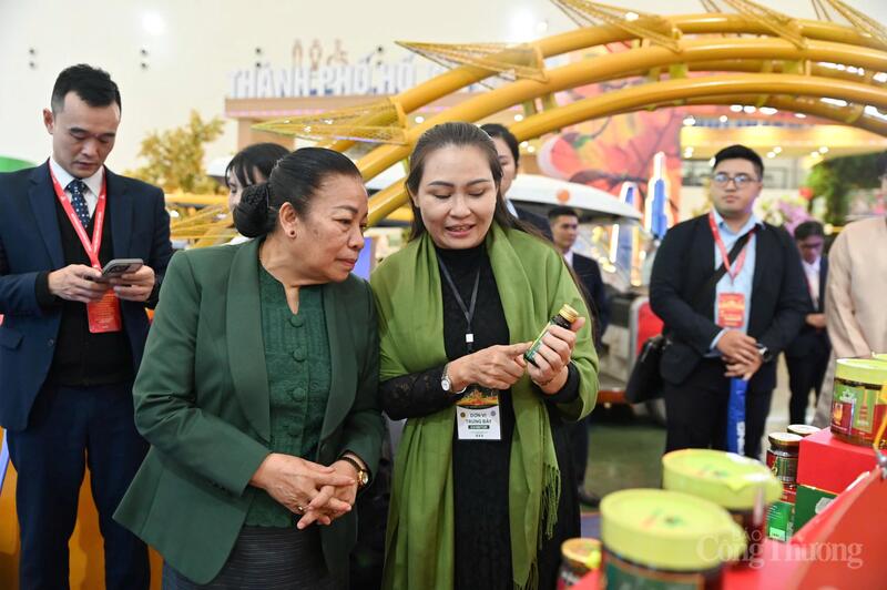 Phó Chủ tịch Quốc hội Lào chăm chú tìm hiểu sản phẩm đặc trưng của doanh nghiệp Việt Nam trưng bày tại hội chợ. Ảnh: Nam Nguyễn