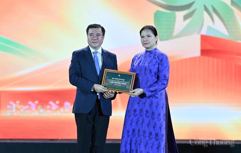 Thứ trưởng Bộ Công Thương Nguyễn Sinh Nhật Tân trao bảng tượng trưng ủng hộ đồng bào miền Trung và miền núi phía Bắc. Ảnh: Nam Nguyễn.