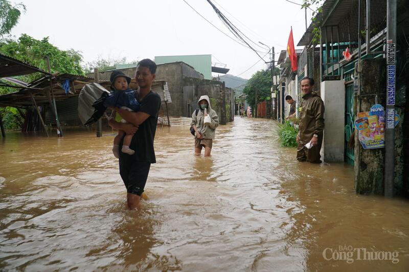 Các em nhỏ theo bố mẹ chạy lụt