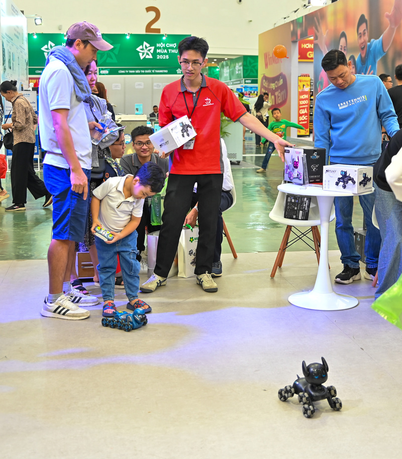 Các em nhỏ thích thú vây quanh những chú chó robot, hào hứng chạm tay và theo dõi từng bước đi uyển chuyển của chúng.