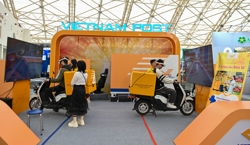 Trong khu vực trưng bày của Tổng công ty Bưu điện Việt Nam (Vietnam Post), người dân xếp hàng để tham gia vào hoạt động tương tác độc đáo: "Một ngày làm bưu tá" bằng công nghệ thực tế ảo (VR). Đây được xem là điểm nhấn thể hiện rõ nét công cuộc chuyển đổi số của ngành bưu chính Việt Nam.