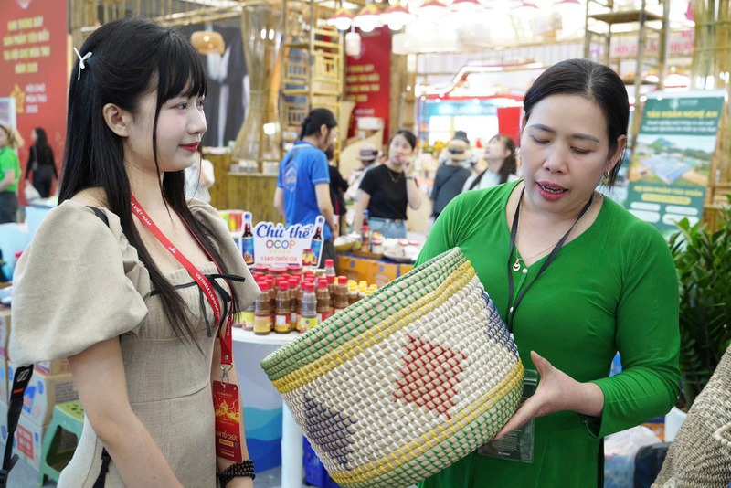 Bà Nguyễn Thị Thắm chia sẻ với phóng viên về sản phẩm tại gian hàng. Ảnh: Diệu Linh