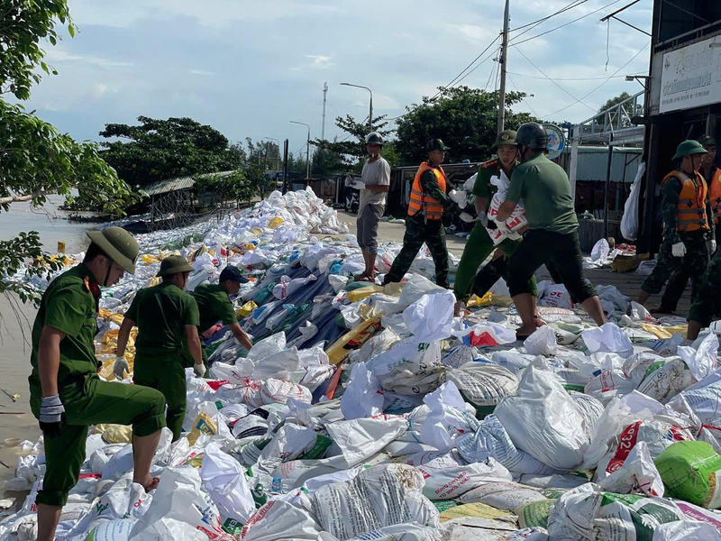Các chiến sĩ công an cùng góp sức để cấp cứu tuyến kè. Ảnh: Nguyễn Dương