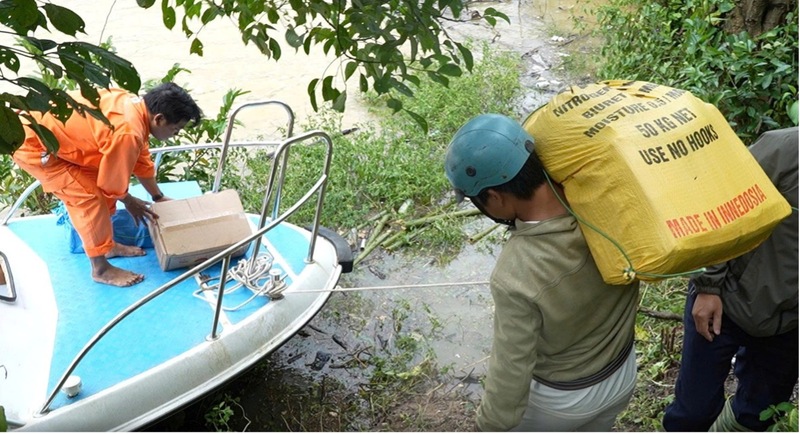 Đưa lương thực, thực phẩm lên cano di chuyển qua hồ thủy điện A Vương vào thôn Z'Lao. Ảnh: Bình An