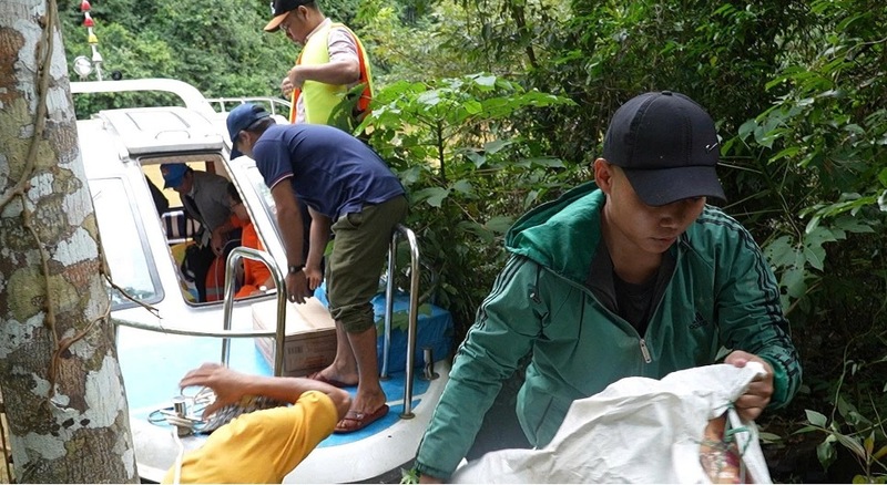 Vận chuyển lương thực, thực phẩm vào trong thôn cho người dân đang còn bị cô lập do đường bộ bị sạt lở. Ảnh: Bình An
