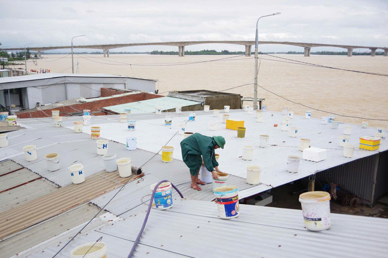 Giúp các hộ dân ven sông gia cố mái nhà. Ảnh: Bình An