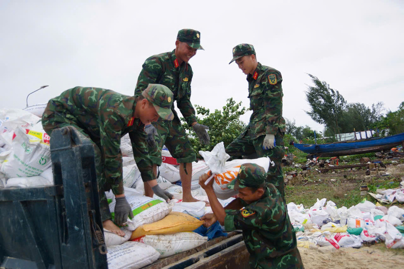 Khẩn trương cùng chính quyền vận chuyển hàng nghìn bao cát để gia cố các điểm sạt lở bờ sông. Ảnh: Bình An