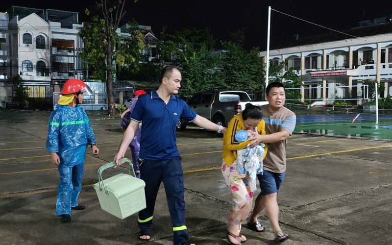 Các chiến sĩ Công an tỉnh Gia Lai hỗ trợ một gia đình có trẻ sơ sinh tới nơi an toàn. Ảnh: ĐVCC