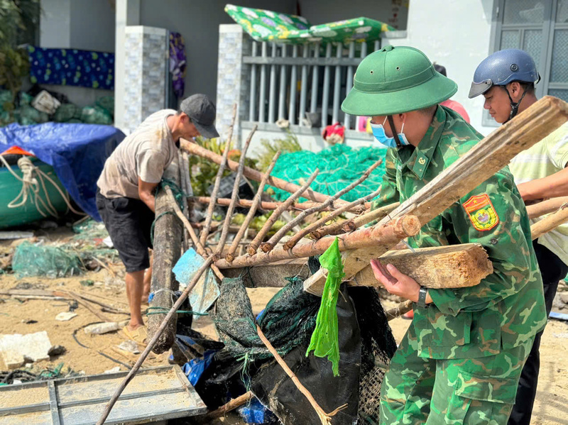 Bộ đội biên phòng giúp dân thu dọn nhà cửa sau cơn bão số 13. Ảnh: Công Lý.