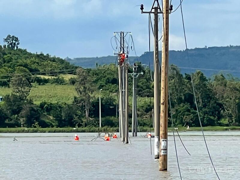 Cán bộ ngành điện ngâm mình trong nước để khắc phục sự cố đường dây do bão số 13 gây nên. Ảnh: Hồng Hoa