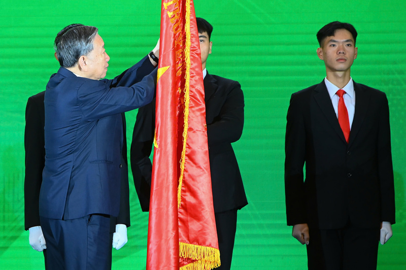 Tổng Bí thư Tô Lâm gắn Huân chương Lao động hạng Nhất lên cờ truyền thống của ngành Nông nghiệp và Môi trường. Ảnh: Thống Nhất/TTXVN