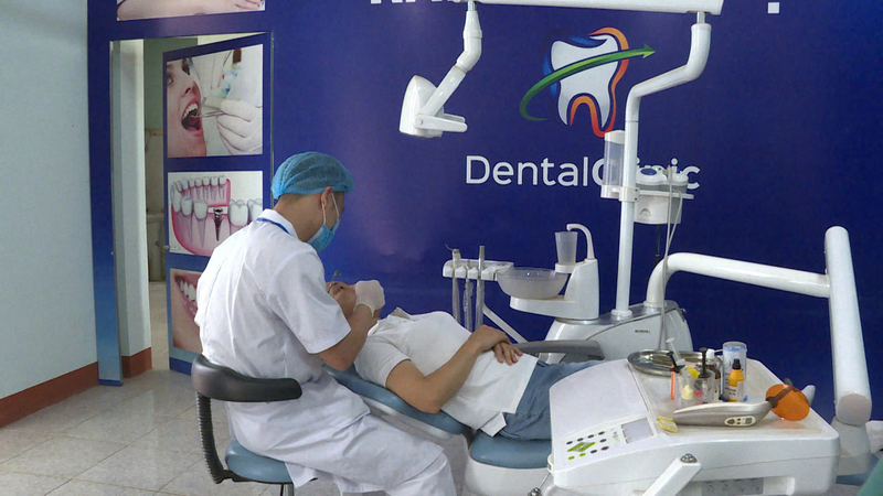 Bác sĩ tại cơ sở y tế tuyến huyện thực hiện dịch vụ nha khoa, cho thấy sự cải thiện rõ rệt về trang thiết bị và chất lượng chuyên môn tại y tế cơ sở