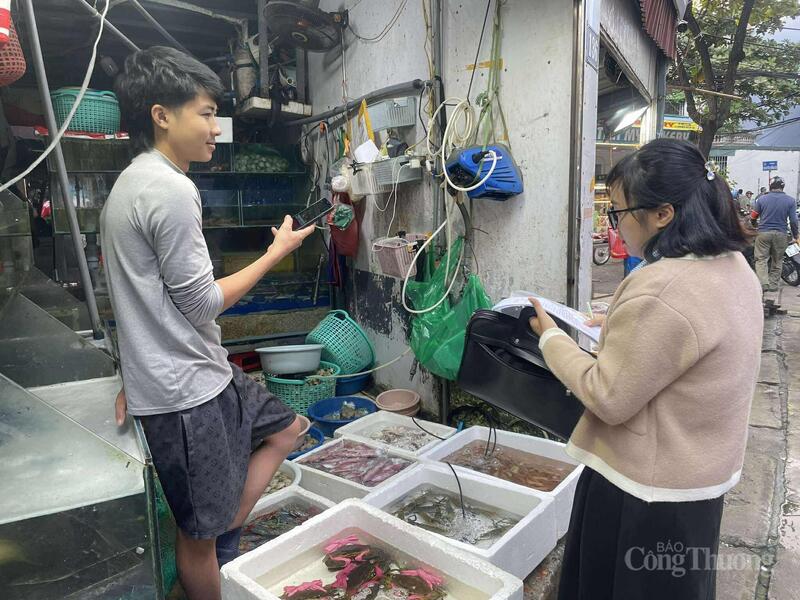 Bà Vũ Thị Thanh Xuân, chuyên viên Phòng Kinh tế Hạ tầng (phường Từ Liêm) vận động người dân không lấn chiếm lề đường buôn bán.