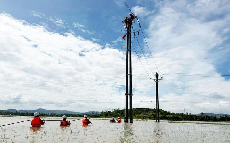 Cán bộ ngành điện ở Đắk Lắk ngâm mình trong nước để khắc phục sự cố đường dây hỏng do bão số 13. Ảnh: Hồng Hoa