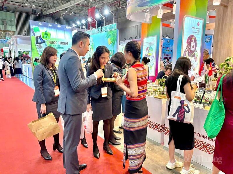 Các cô gái trong trang phục truyền thống giới thiệu sản phẩm cho khách hàng. Ảnh: Bích Thu.