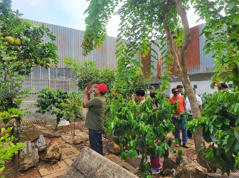 Khách nước ngoài trải nghiệm mô hình cà phê chồn Kiên Cường tại vườn. Ảnh: Kiên Cường