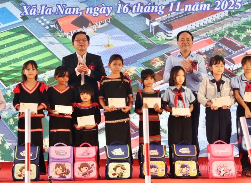 Phó Thủ tướng Hồ Quốc Dũng và Chủ tịch UBND tỉnh Phạm Anh Tuấn trao tặng các phần quà cho các em học sinh.