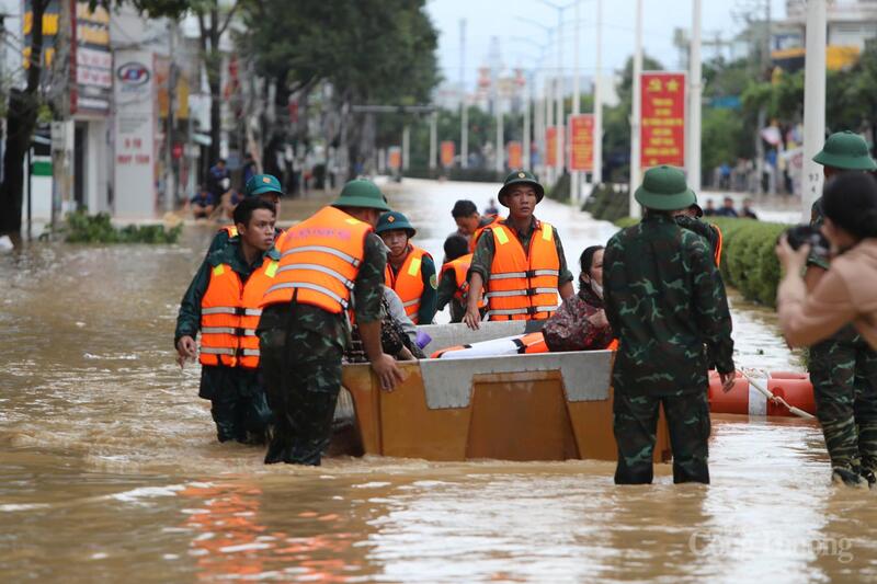 Lực lượng chức năng đưa người dân ra khỏi khu vực nước ngập sâu.
