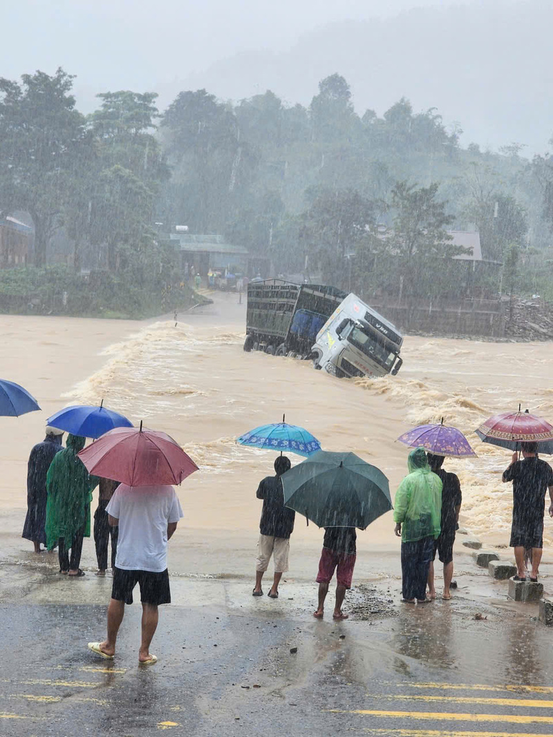 Hình ảnh chiếc xe ô tô vận tải cố vượt qua ngầm nước lũ đang dâng (Ảnh: Đ. Nghĩa)