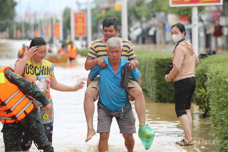 Người dân hỗ trợ nhau ra khỏi khu vực ngập úng.