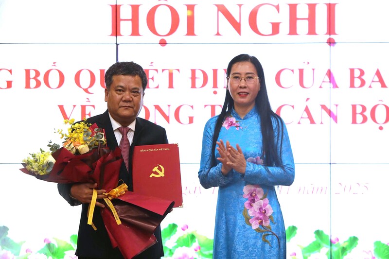 Đồng chí Bùi Thị Quỳnh Vân trao quyết định và tặng hoa chúc mừng đồng chí Trần Phong.